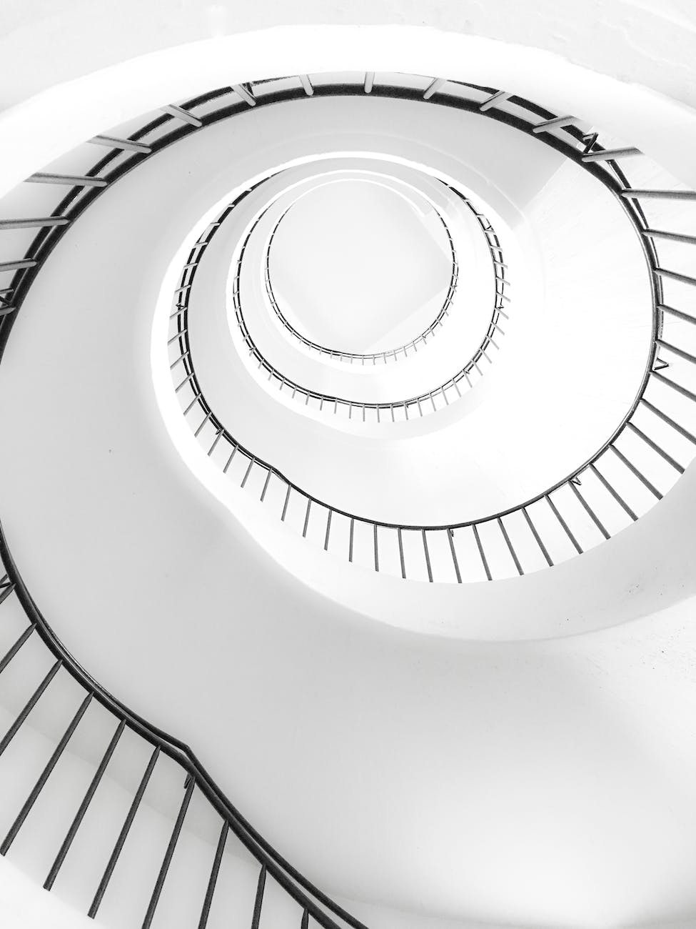 white spiral stairs with black metal railings